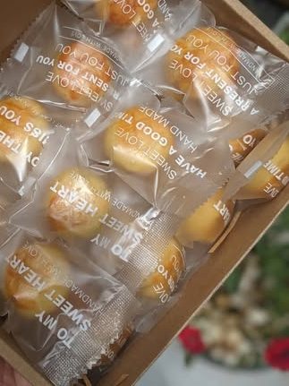 Hộp kraft mở nắp xếp đầy bánh dứa, mỗi chiếc gói trong túi trong riêng